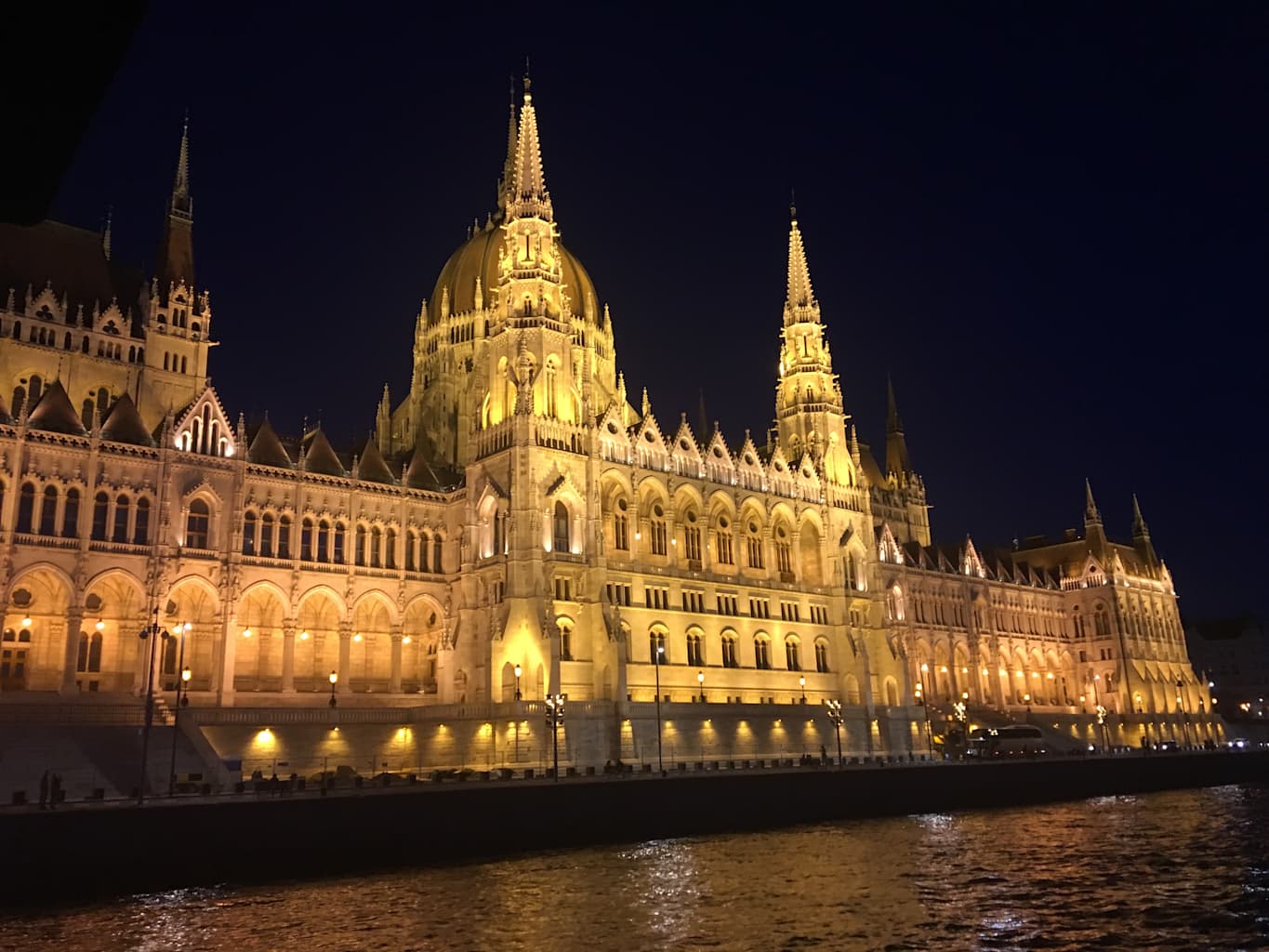 A large, backlit building in Prague during the evening.